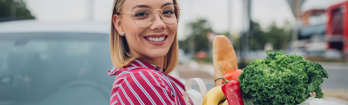 lady smiling holding a bag of groceries
